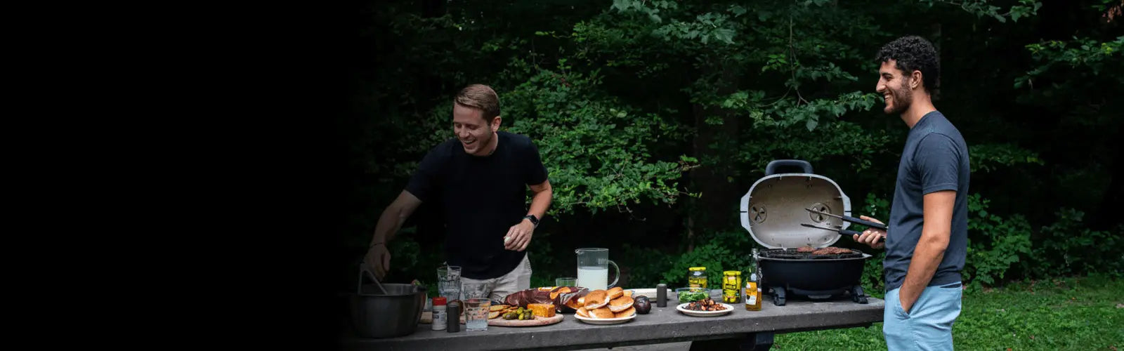 a man standing next to a portable grill on a table with food on it